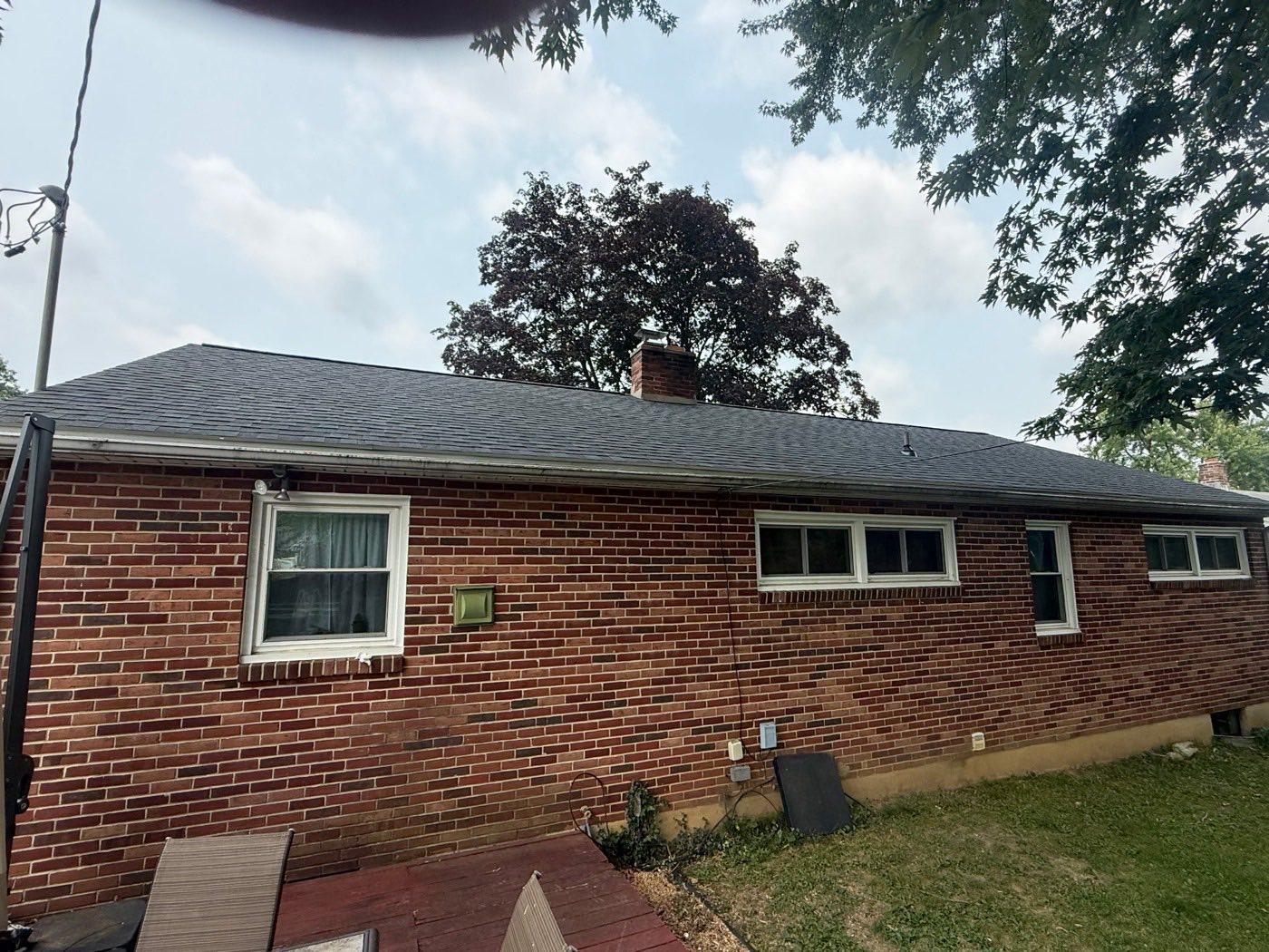 Brick ranch home with a new charcoal architectural shingle roof and brick chimney