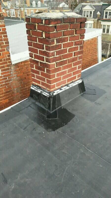 Brick chimney with new flashing on a flat rubber membrane roof in York County