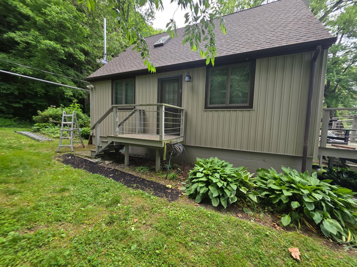Lake cabin with a freshly installed dark shingle roof and deck — Dallastown Roofing project