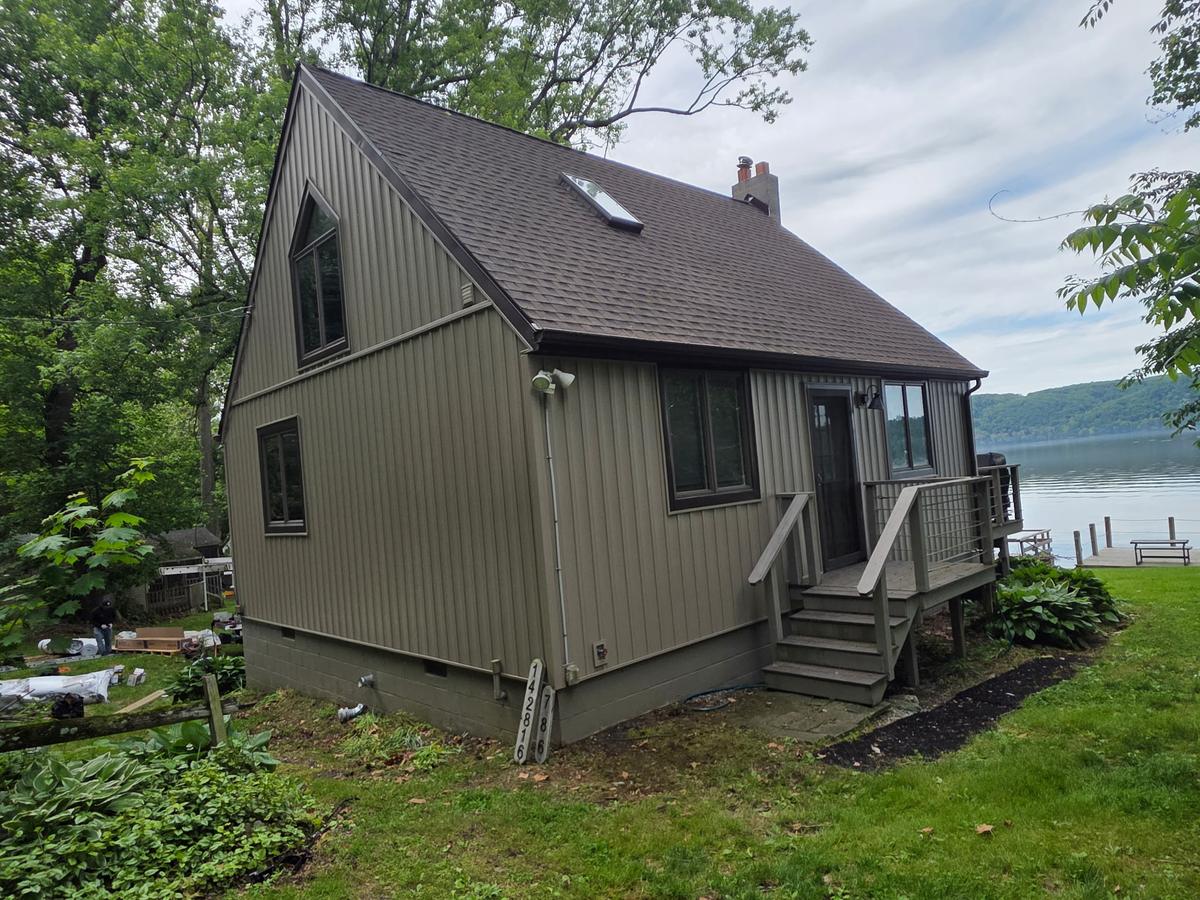 Board-and-batten cottage with a new roof overlooking the lake