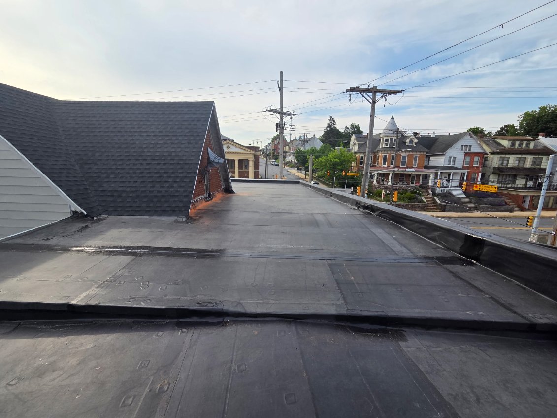 Freshly installed flat rubber roof on a downtown commercial building overlooking the town