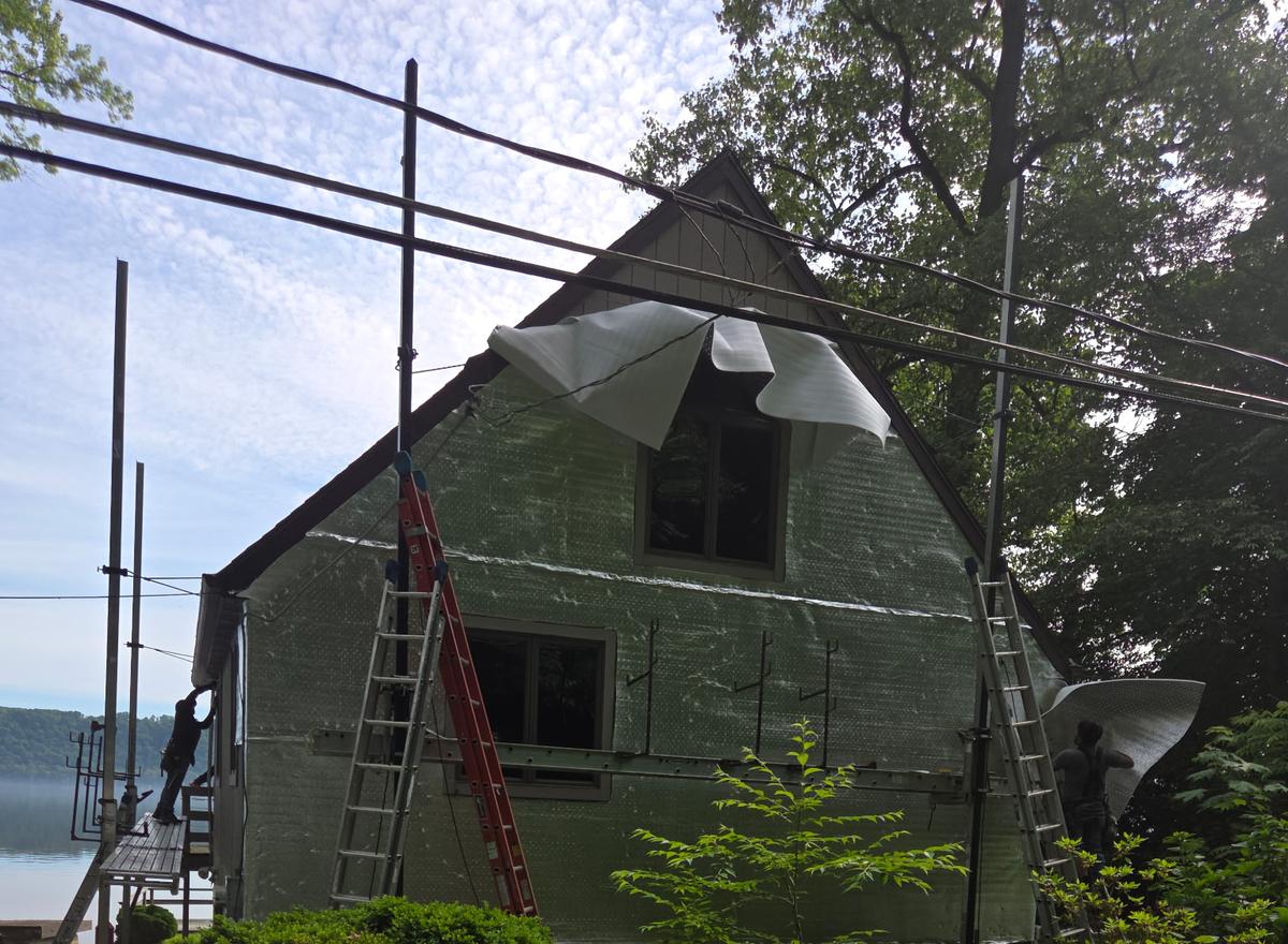 Re-roof in progress with full scaffolding on a lakeside home
